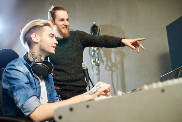 Collègues joyeux faisant de la musique en studio