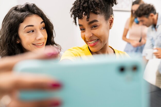 Collègues multiethniques prenant des selfies au bureau