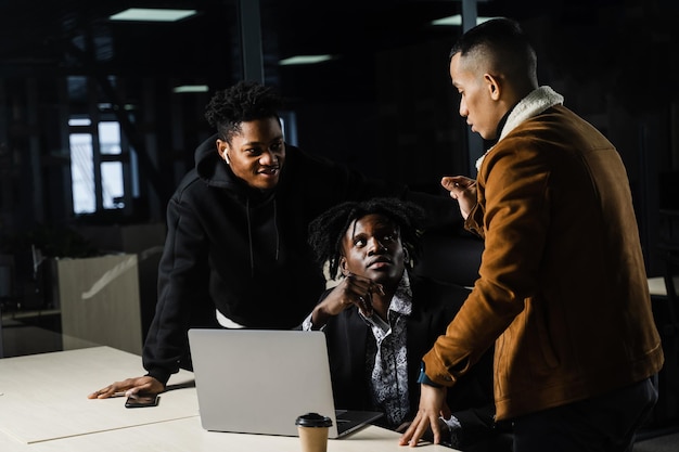 Collègues noirs et asiatiques travaillant ensemble sur un ordinateur portable Travail d'équipe multiethnique et discussion d'un projet de travail en ligne