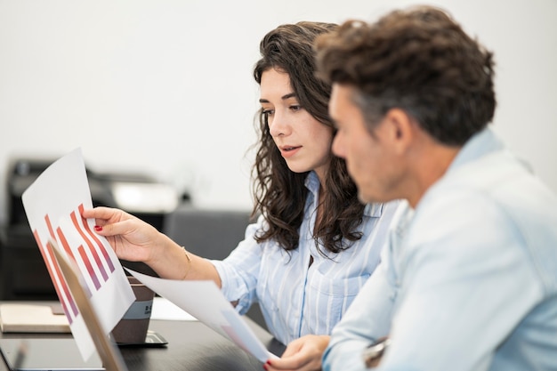 Collègues parlant en collaboration avec des statistiques