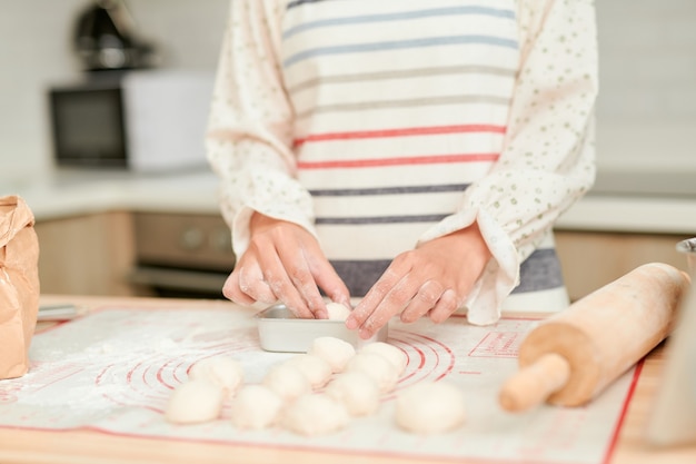 Collègues pétrir la pâte avec un rouleau à pâtisserie dans la cuisine de la boulangerie