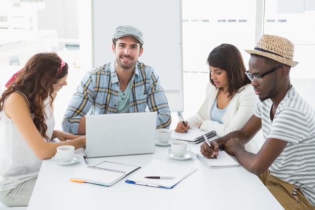 Collègues prenant des notes et utilisant un ordinateur portable