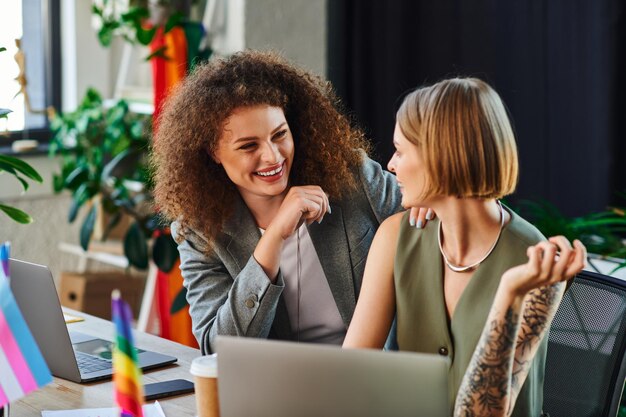 Des collègues qui rient et se soutiennent dans un bureau vibrant célébrant la diversité