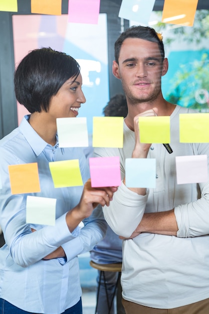 Collègues regardant des notes autocollantes