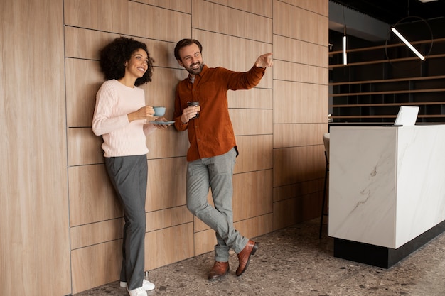 Photo collègues smiley plein coup avec des tasses à café