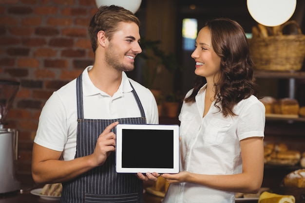 Collègues souriants montrant une tablette