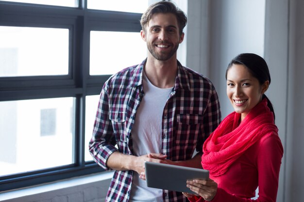 Collègues tenant une tablette numérique au bureau