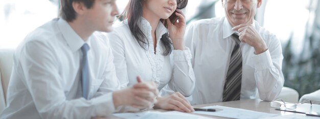 Collègues de travail analysant les statistiques financières assis à un bureau au bureau.