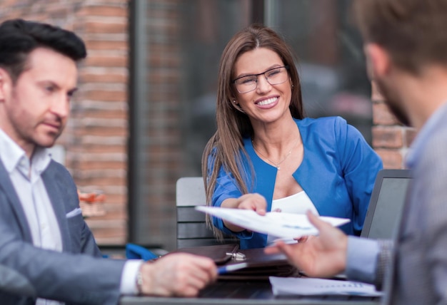 Des collègues de travail discutent des documents assis au café de la table