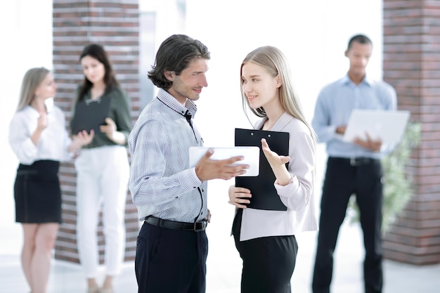 Collègues de travail parlant debout dans un bureau moderne