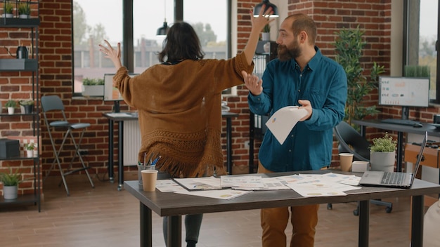 Des collègues de travail se disputant et se battant au sujet d'un projet d'entreprise, essayant de travailler sur des papiers avec des tableaux de taux. Femme agressive jetant des fichiers dans l'air tout en se disputant et en se querellant avec l'homme.