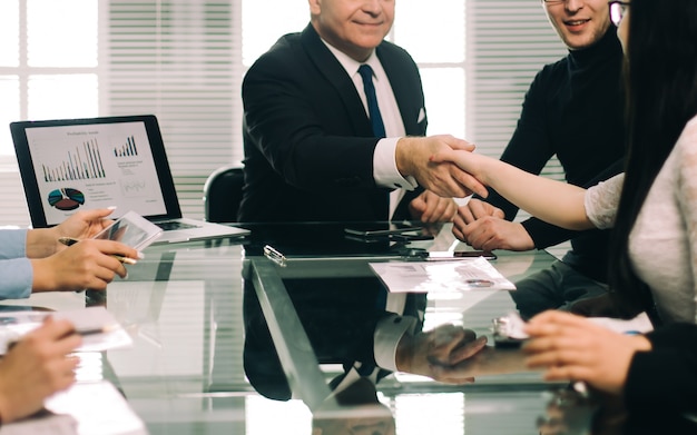 Des collègues de travail se serrant la main lors d'une réunion de travail. le concept de travail d'équipe