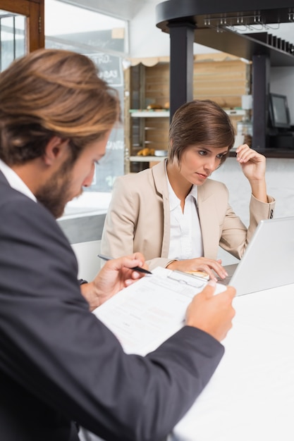 Collègues de travail travaillant sur leur pause au café