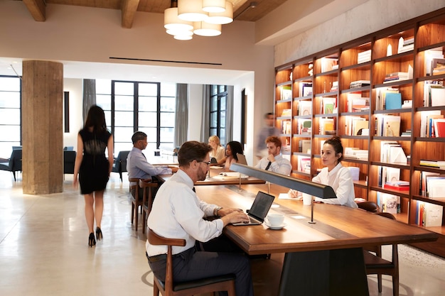 Collègues travaillant à des bureaux dans un espace de bureau décloisonné très fréquenté