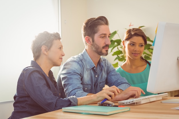 Collègues utilisant un ordinateur portable au bureau