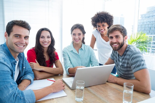 Collègues utilisant un ordinateur portable au bureau