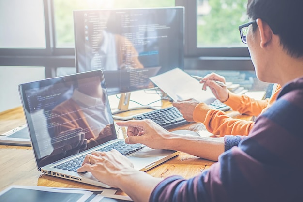 Des collègues utilisant un ordinateur portable à leur bureau au bureau