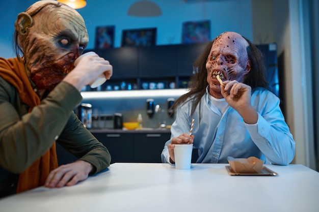 Collègues zombies mangeant pendant la pause-café à l'heure du déjeuner