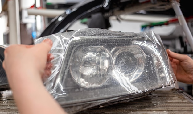 Coller un film protecteur en polyuréthane contre les éclats sur le verre des phares de la voiture