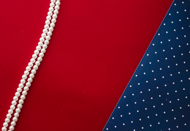 Collier de bijoux en perles et fond abstrait à pois bleus sur fond rouge