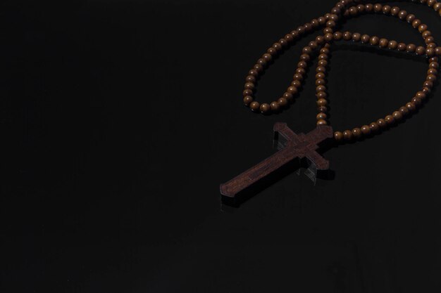 Collier croix chrétienne en bois sur fond noir