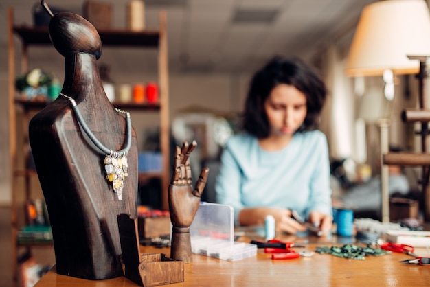 Photo collier fait main sur mannequin en bois, couture.