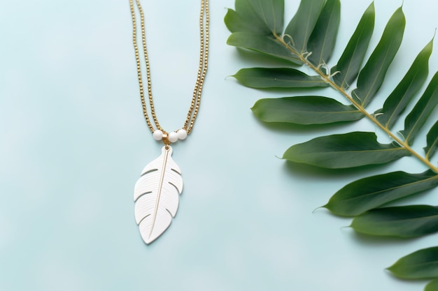 Un collier avec une feuille à côté d'une plante verte.