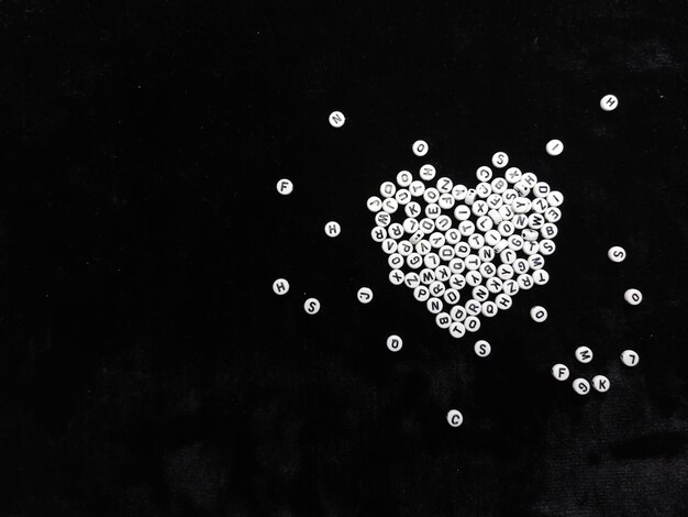 Photo un collier en forme de coeur est sur un fond noir avec le mot amour.