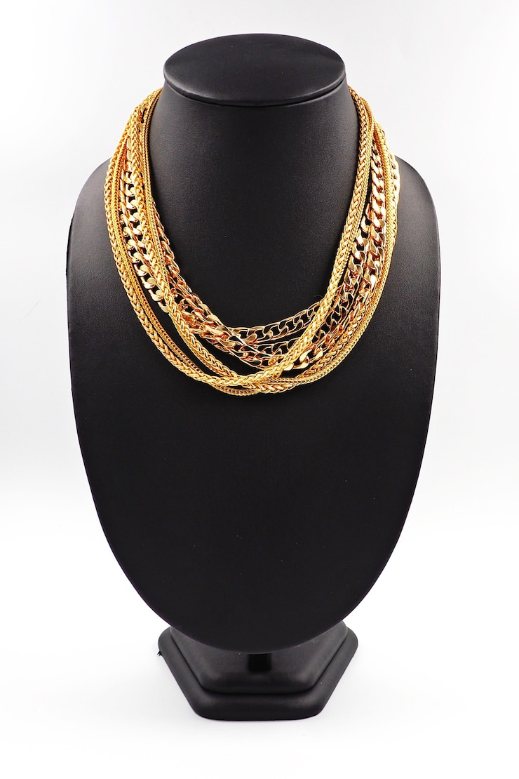 Photo collier en or sur le présentoir de collier.