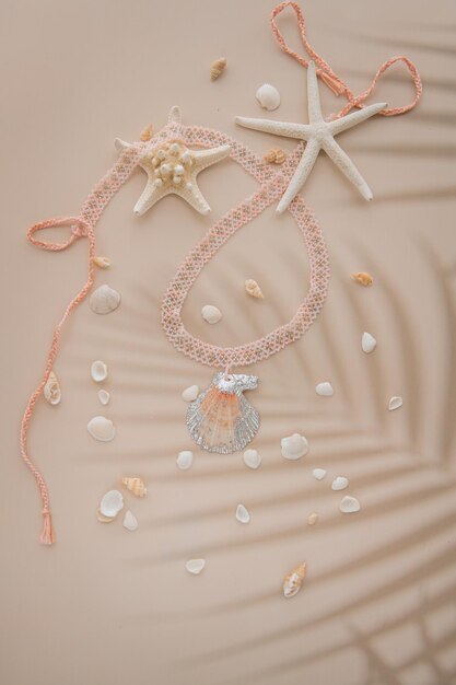 Un collier de pendentifs fait d'une palourde et de perles entourées de petites coquillages et d'étoiles de mer
