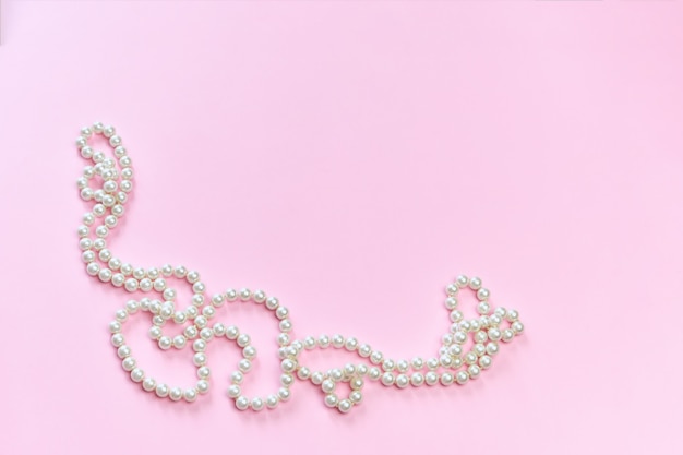 Collier de perles sur surface rose
