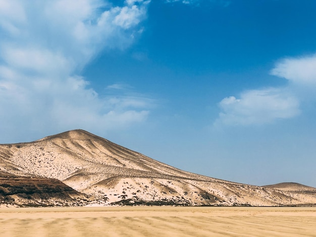 Colline de sable sous un ciel nuageux