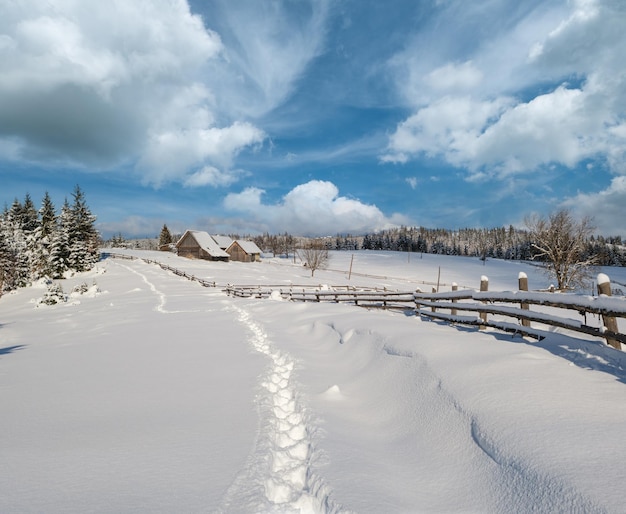 Des collines de campagne, des bosquets et des terres agricoles en hiver dans un village alpin isolé.