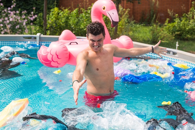 Écologie, déchets plastiques, urgence environnementale et pollution de l'eau - homme choqué debout dans une piscine sale.