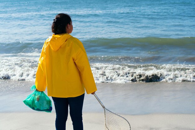 Écologiste avec plage de nettoyage de sac poubelle