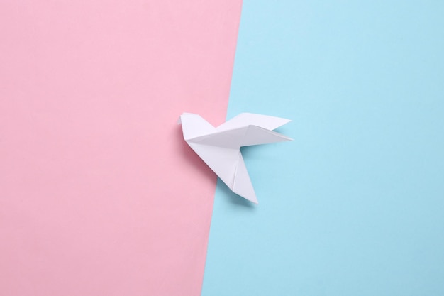 Colombe en origami sur fond pastel bleu rose Vue de dessus