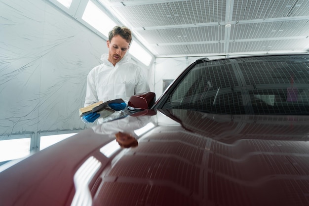 Le coloriste automatique dans la chambre de peinture sélectionne la couleur de la peinture de la voiture avec des échantillons