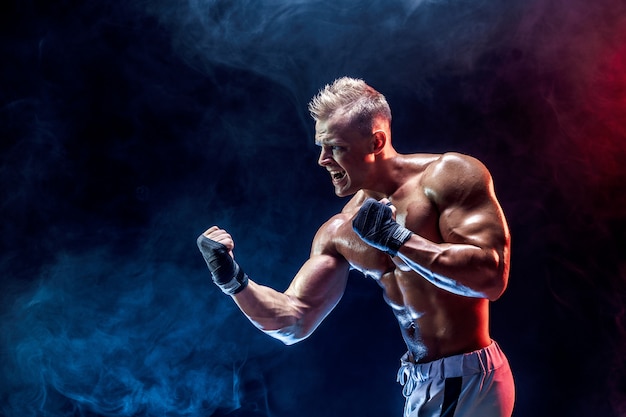 Combattant aux seins nus musclé dans des gants de boxe