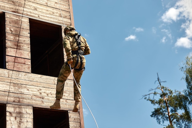 Un combattant des forces spéciales descend d'un gratte-ciel pour prendre d'assaut l'appartement Concept de lutte contre le terrorisme de la police Technique mixte