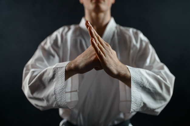 Combattant de karaté masculin en kimono blanc, signe de bienvenue. Karateka sur l'entraînement, les arts martiaux, l'entraînement avant la compétition de combat