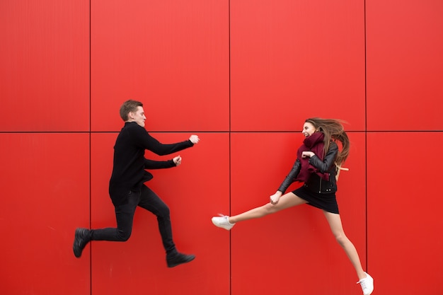 Combattez en saut. Un homme et une femme sur fond rouge.