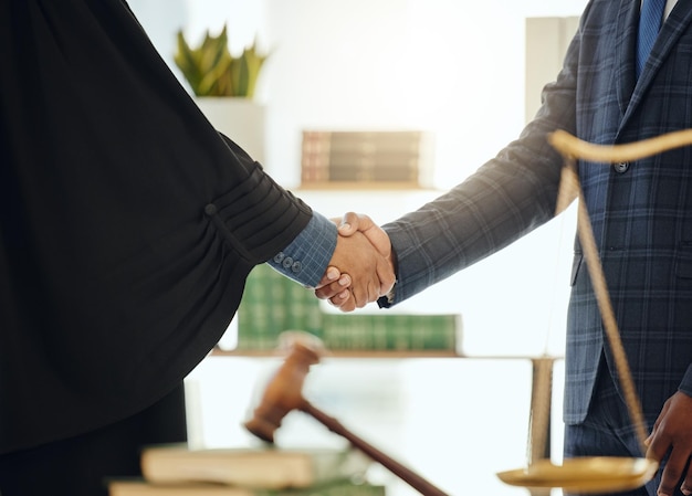 Combattons ensemble l'injustice Photo de deux avocats méconnaissables se serrant la main au travail