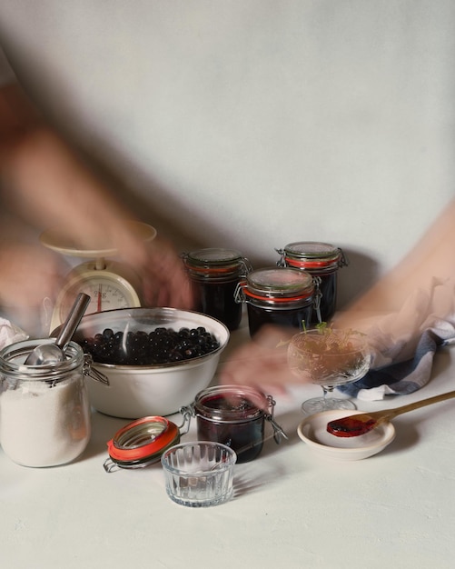 Photo combinaison d'une longue exposition et d'une double exposition de mains faisant de la confiture de mûres