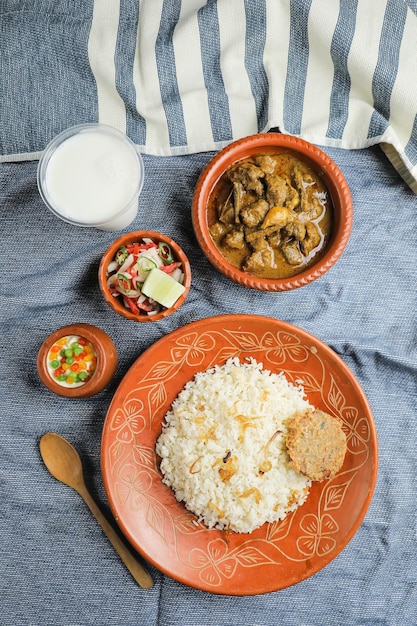 Combo de boeuf Chui Jhal avec riz pulao shami kabab korma karahi kala buna boondi rabri borhani et salade servie dans un plat isolé sur un tapis vue de dessus de la nourriture indienne et bangladaise