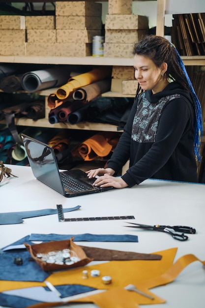 Photo commande en ligne de couture de couturière jeune femme propriétaire d'entreprise regardant l'écran de l'ordinateur portable