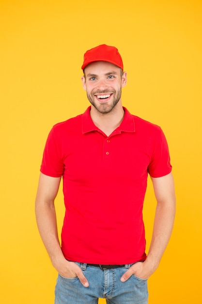 Commande de nourriture livreur caissier vacance Embauche employé de magasin heureux gars revendeur mur jaune Le personnel du café du restaurant voulait un service de livraison d'homme en t-shirt rouge et une casquette assistant de magasin amical