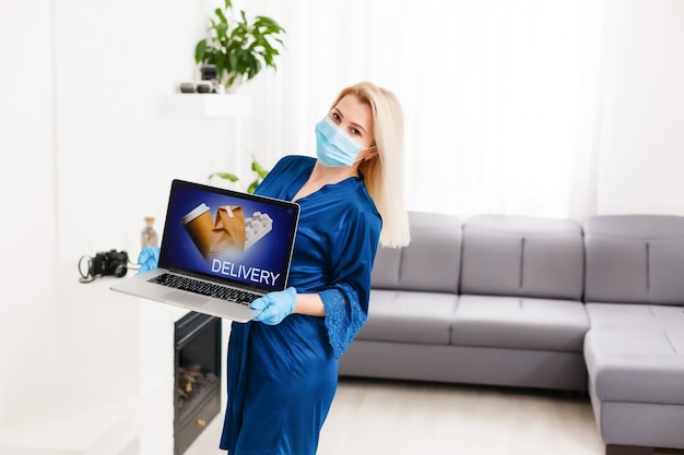 commander de la nourriture et des médicaments dans une boutique en ligne pendant la quarantaine et l'épidémie, portrait d'une femme portant un masque médical