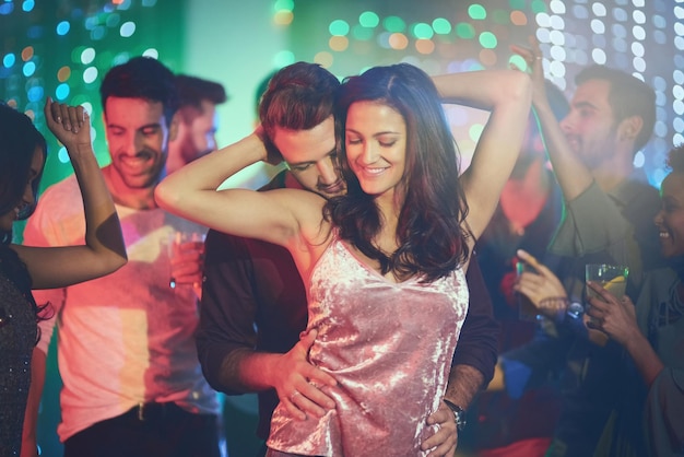 Comme personne d'autre n'est autour Photo d'un jeune couple affectueux dansant sur une piste de danse bondée dans une discothèque