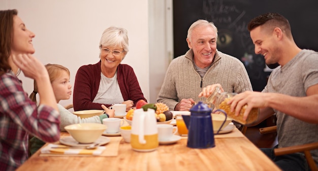 Commencer la journée avec un petit-déjeuner sain Photo d'une famille multigénérationnelle prenant son petit-déjeuner ensemble dans la cuisine