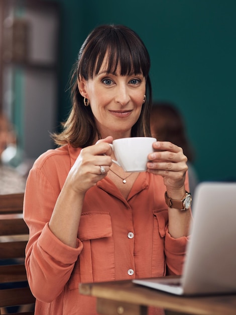 Commencer ma journée correctement Portrait d'une jolie femme d'âge moyen prenant une tasse de café à l'intérieur d'un café pendant la journée